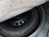 a close up of a car ' s tire in the trunk of a vehicle