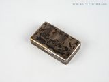 a silver cigarette case sitting on a white surface