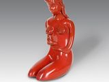 une image représentant une sculpture rouge d'une femme tenant un bébé dans ses bras