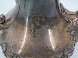 a silver vase that has a monogram on it