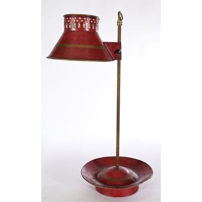 a red table lamp with a red shade on top of it