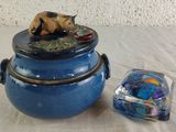 a blue bowl with a bear on top of it next to a glass container