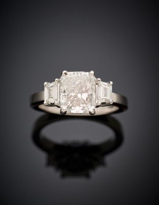 a diamond three - stone ring with baguets of diamonds