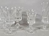 four glass goblets and a wine glass on a table