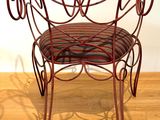 a red metal chair with a striped seat on a wooden floor