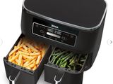 une photo d'une friteuse à air chaud noire avec deux plateaux remplis d'aliments