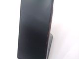 a black cell phone on a stand on a white surface