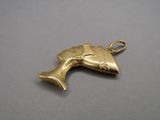une image représentant un pendentif en or orné d'une tête de poisson