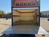 the back end of a trailer with the door open in a parking lot