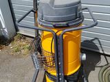 a yellow and black vacuum on a cart next to a building