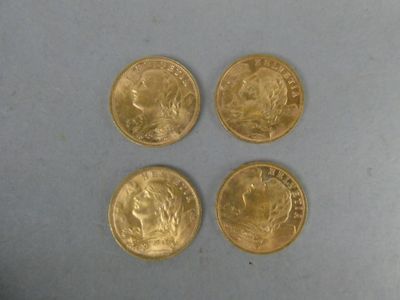 four gold coins sitting on top of a table next to each other