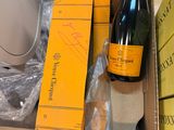 une bouteille de champagne posée sur une table à côté d'une boîte de livres