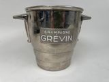 un seau à glace en argent sur lequel est inscrit le mot « Grevin »