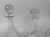 three glass decanters sitting on a white surface