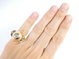 a woman ' s hand with a gold ring on it
