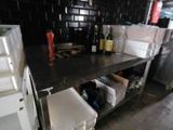une cuisine avec un plan de travail noir et un mur carrelé noir