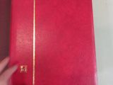 a person holding a red book on a table