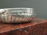 a silver bowl sitting on top of a red table