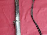 une épée posée sur un tissu rouge