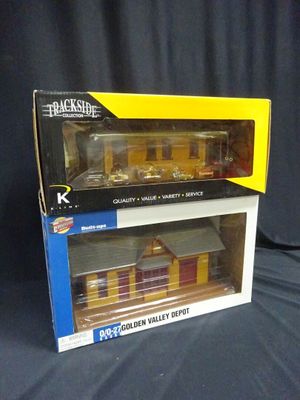 two boxed boxes of toy trains sitting on a black surface