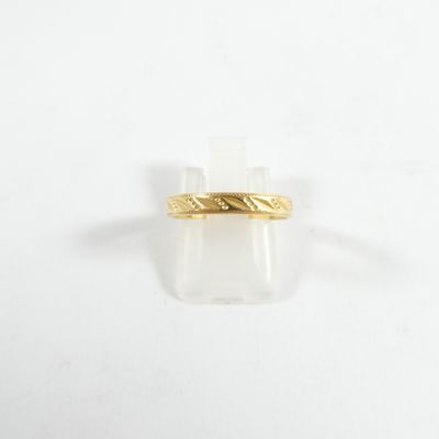 gros plan d'une bague en or sur une surface blanche
