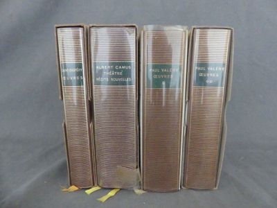 trois livres sont empilés sur une surface grise