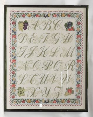 a framed cross stitch sample of a fruit and vegetable alphabet