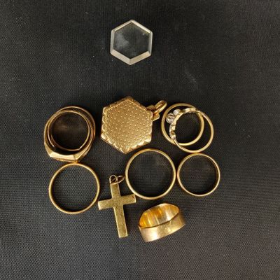 un gros plan sur un lot de bagues et une croix posés sur une table