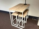une table avec trois tabourets et une horloge accrochée au mur
