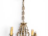an antique brass chandelier with three candles hanging from the ceiling