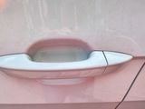 a pink car door handle with a hole in it