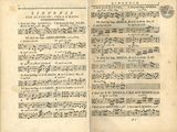 an old book with music notes in it sitting on a table