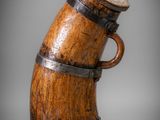 a close up of a wooden vase with a handle on a gray background