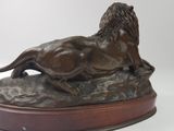 bronze statue of a lion on a rock on a white background