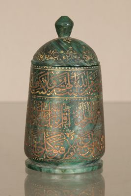an old metal container with arabic writing on it sitting on a table