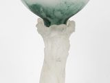 une image représentant un vase blanc surmonté d'un bol en verre vert
