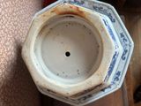 a blue and white vase with a hole in it