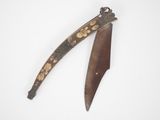 an old knife with a wooden handle sitting on top of a white surface