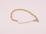un bracelet à chaîne en or avec une breloque en forme de cœur