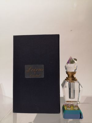 un flacon de parfum posé à côté d'un livre sur une table