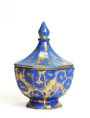 a blue and gold bowl with a lid on a white surface