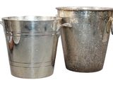 two metal buckets sitting next to each other on a white surface