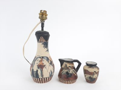 trois vases et une lampe posés sur une surface blanche
