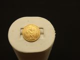 une image montrant un gros plan d'une pièce d'or posée sur un objet blanc