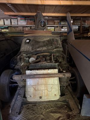 une vieille voiture qui prend la poussière dans un garage