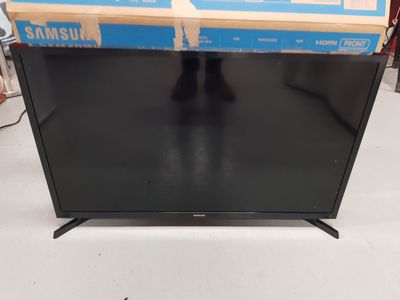 a black television sitting on top of a table next to a box