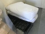 a small bed in the corner of a room next to a wall