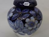 a blue and white vase with flowers painted on it