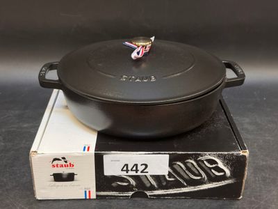 un pot noir posé sur une boîte, elle-même posée sur une table