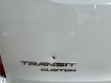 the rear end of a white car with the word transit custom written on it